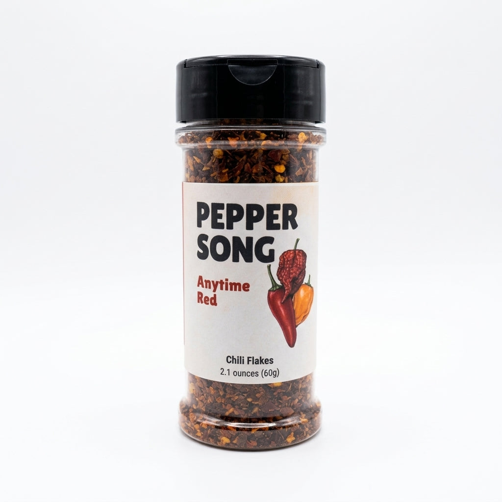 A clear plastic spice jar of Pepper Song Anytime Red Chili Flakes with a black shaker lid and a white label, set against a plain white background.