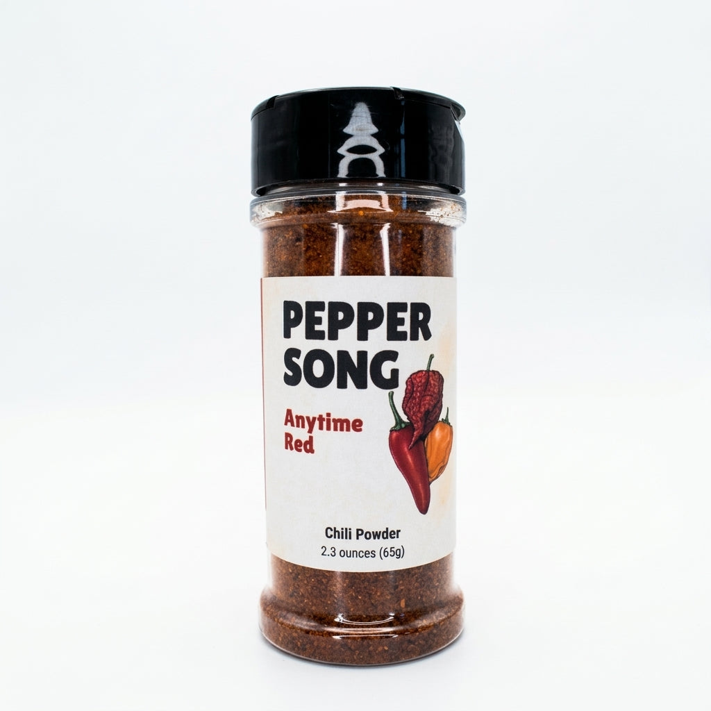 A clear plastic spice jar of Pepper Song Anytime Red Chili Powder with a black shaker lid and a white label, set against a plain white background.