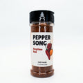 A clear plastic spice jar of Pepper Song Anytime Red Chili Powder with a black shaker lid and a white label, set against a plain white background.