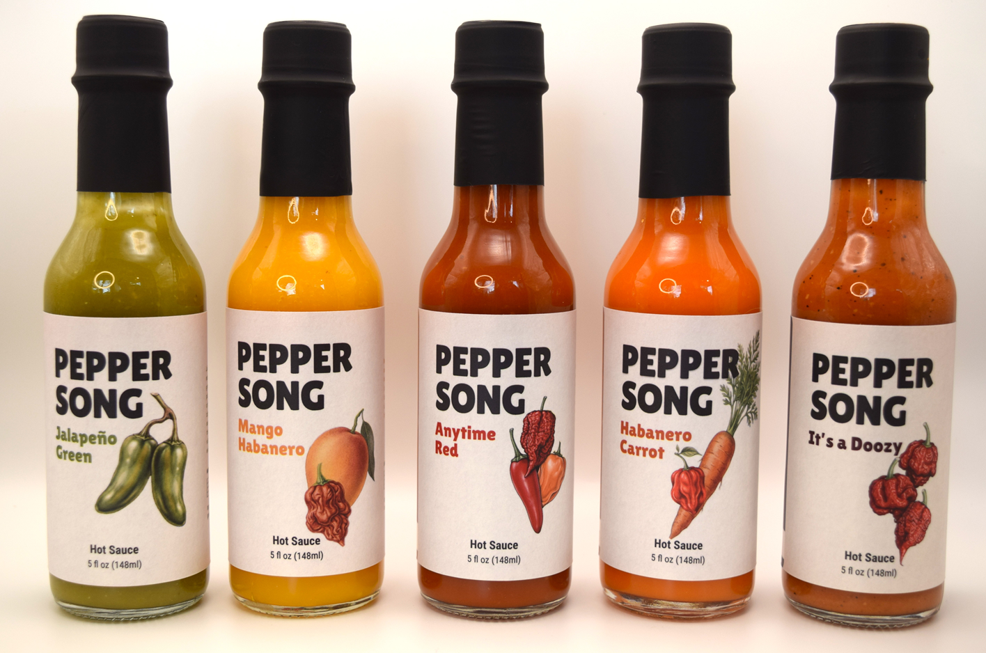 Five bottles of Pepper Song hot sauce with different flavors on a white background
